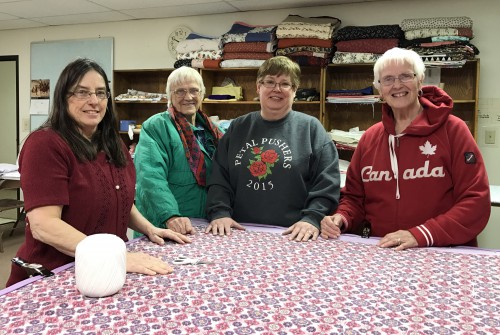 Quilting volunteers Pam Toney, left, April Davis, Sherry Fick, and Susie Engelman, gather together in their “quilting classroom” at Grace Lutheran Church in Liberal. More than a dozen volunteers worked to produce more than 220 quilts in their first year of quilting together. 